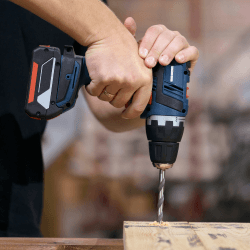 A drill shown drilling into some wood